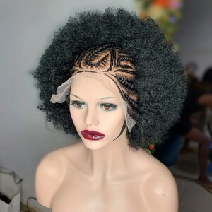 May include: A black wig on a mannequin head featuring a lace front base with intricate cornrow braids at the crown and voluminous, tightly coiled afro-textured hair extending outward from the braided section to create a full, rounded shape.