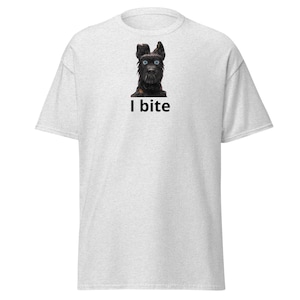 May include: Light gray t-shirt featuring a black dog with blue eyes and the text "I bite" in black. The dog is centered on the front of the shirt. The shirt has short sleeves and a crew neck.