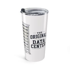 May include: A white stainless steel tumbler with a clear plastic lid featuring a black line drawing of a tall, multi-shelf bookcase filled with books and the dark blue text that reads THE ORIGINAL DATA CENTER in a bold, sans-serif font.