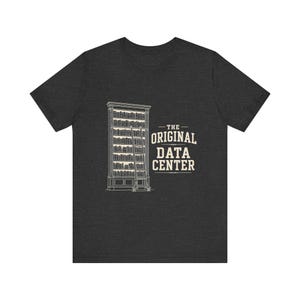 May include: A dark charcoal gray short-sleeve t-shirt featuring a white line art graphic of a tall bookshelf with a rolling ladder. To the right of the bookshelf, the text reads THE ORIGINAL DATA CENTER in a bold, serif, white font.