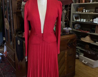 This red knit sweater and pleated skirt is cozy and smart