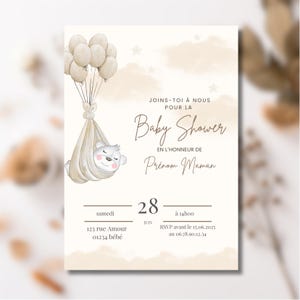 Pode incluir: Um convite para chá de bebé com um design em aquarela. O convite apresenta um fundo bege com um urso de desenho animado em uma tipoia segurada por balões. O texto diz "Baby Shower" e inclui detalhes do evento.