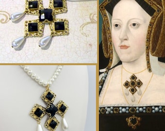 May include: A gold necklace with a black cross pendant and pearl drops. The cross is made of five black stones set in gold. The necklace is on a white background.