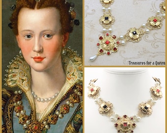 May include: A gold necklace with red and black jewels, pearls, and a dangling pearl. The necklace is on a white surface. "Treasures for a Queen" is written on the surface.