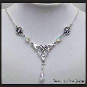 Puede incluir: Collar de plata con nudo celta, un colgante de cristal en forma de l&aacute;grima y dos acentos de cristal redondos. El collar tiene una cadena de plata y est&aacute; adornado con dos c&iacute;rculos de plata con dise&ntilde;os intrincados.