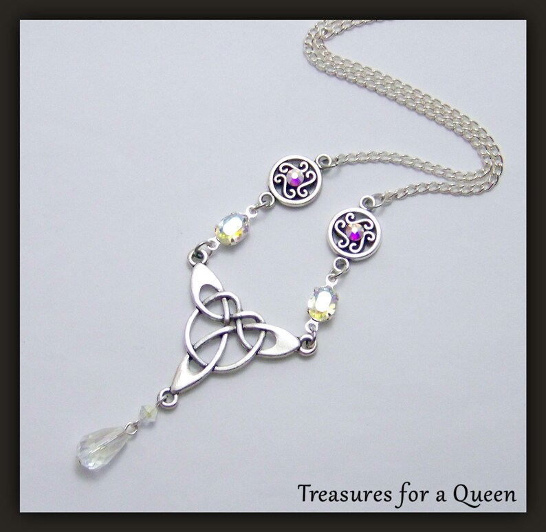 Puede incluir: Collar de plata con nudo celta, un colgante de cristal en forma de l&aacute;grima y detalles de cristal transparente. El collar presenta dos dijes circulares con dise&ntilde;os intrincados y un cristal morado en cada uno.