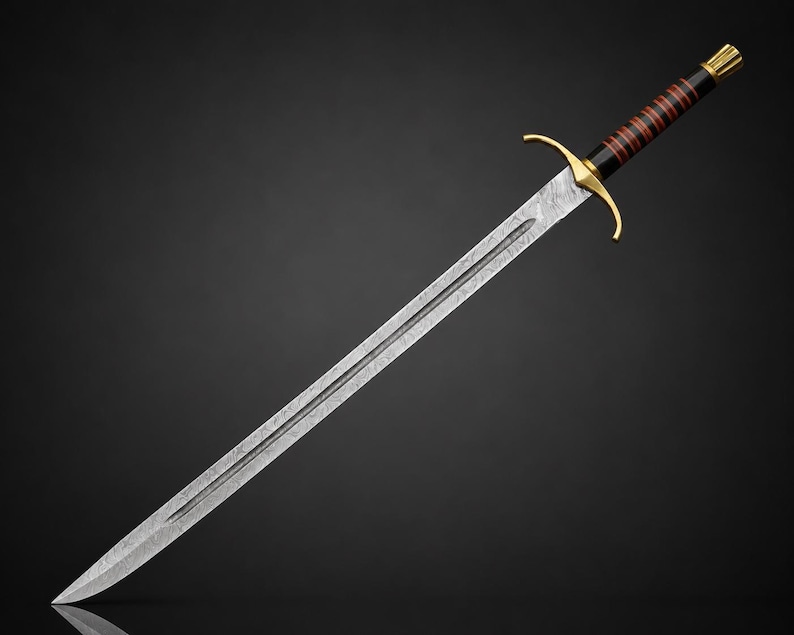 May include: A sword with a patterned Damascus steel blade featuring a central fuller. The hilt includes a gold-colored crossguard, a black grip wrapped with thin red bands, and a gold-colored pommel cap at the end of the handle.