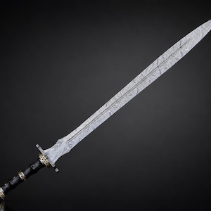 May include: A double-edged sword featuring a long, pointed blade with a distinct wavy, layered metal pattern. The handle is black with gold-colored metal accents at the pommel, grip, and crossguard, showcasing intricate decorative detailing.