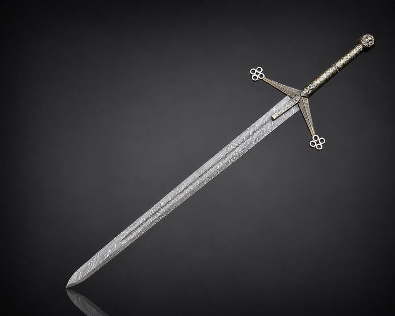 May include: A double-edged sword featuring a patterned Damascus steel blade with a visible wavy grain. The hilt includes a crossguard with four-lobed quatrefoil terminals and a textured metallic grip ending in a circular pommel.