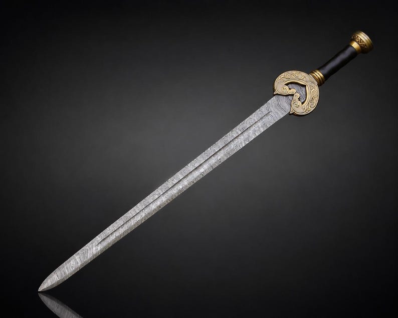 May include: A straight sword with a double-edged blade featuring a visible folded steel pattern. The hilt includes a gold-colored metal guard with ornate scrollwork, a black cylindrical grip, and a matching gold-colored pommel at the end.