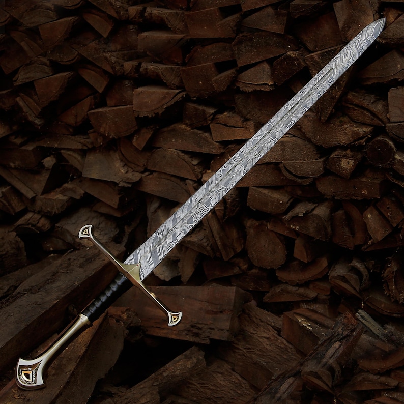 May include: A double-edged sword featuring a blade with a distinct wavy, layered metal pattern. The hilt includes a gold-toned crossguard and a pommel with decorative triangular accents, while the grip is wrapped in black material.