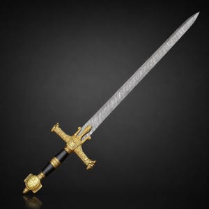 May include: A sword featuring a long, pointed blade with a distinct wavy Damascus steel pattern. The hilt is composed of a black cylindrical grip, a gold-colored crossguard with ornate detailing, and a gold-colored pommel with a star emblem.