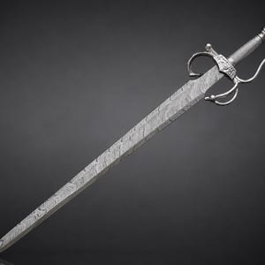 May include: A silver-toned sword featuring a blade with a distinct wavy Damascus steel pattern. The hilt includes a detailed metal crossguard with curved quillons and a textured grip, ending in a rounded pommel at the base of the handle.