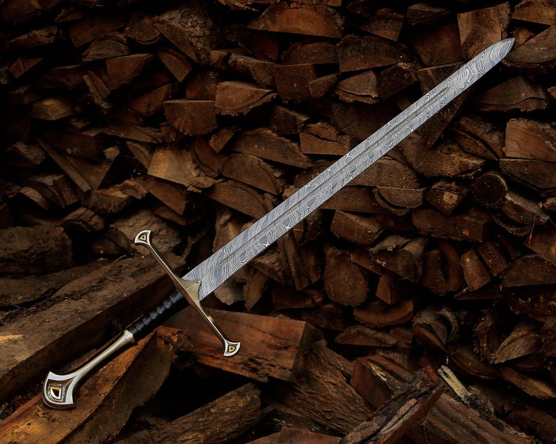 May include: A long sword featuring a double-edged blade with a distinct wavy Damascus steel pattern. The hilt includes a metallic crossguard with triangular accents, a black leather-wrapped grip, and a curved pommel with a metallic inlay detail.