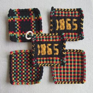 Pode incluir: Cinco pegadores tecidos em preto, vermelho, amarelo e verde. Dois pegadores apresentam o ano "1865" em amarelo. Um pegador tem um anel branco preso. Os pegadores têm formato quadrado e uma borda trançada.