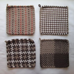 May include: Four square potholders featuring woven patterns. The top left has tan, brown, and orange stripes. The top right has a brown and white checkered pattern. The bottom left has a brown and white houndstooth design. The bottom right is color-blocked.