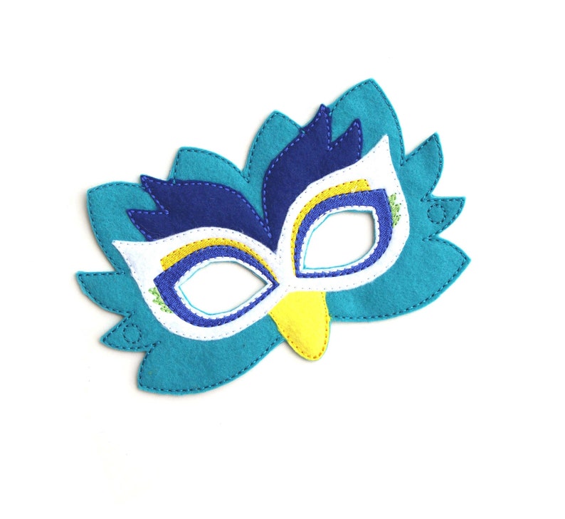 May include: A blue, yellow, and white felt mask with a bird design. The mask has a beak and eye holes.