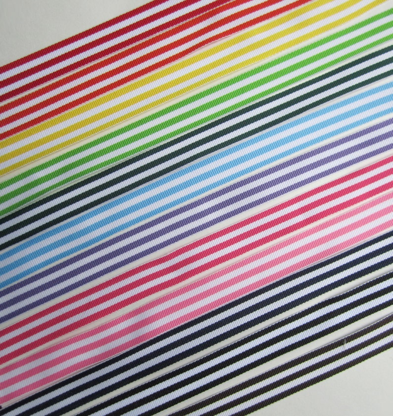 May include: A set of striped ribbon in various colors, including red, yellow, green, blue, purple, pink, and black. The ribbon is arranged in a diagonal pattern, with the stripes running parallel to each other.
