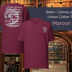 K&ouml;nnte beinhalten: Unisex-T-Shirt aus maroonfarbener Baumwolle. Auf der R&uuml;ckseite des Shirts befindet sich eine wei&szlig;e Grafik eines Sch&auml;dels mit Krone und dem Text "HE WHO CANNOT COMMAND HIMSELF WILL ALWAYS BE A SERVANT". Auf der Vorderseite des Shirts befindet sich eine kleinere Sch&auml;delgrafik.