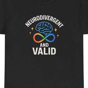 May include: Black t-shirt with the words "NEURODIVERGENT AND VALID" in white, with a brain graphic and an infinity symbol in orange, blue, and green. The shirt is a crew neck and has a tag on the upper back.