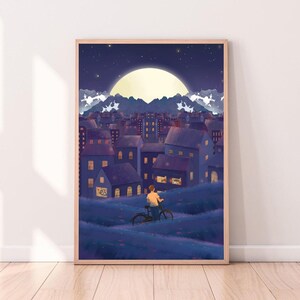 May include: A framed art print depicts a nighttime cityscape with a large moon and starry sky. A person rides a bicycle on a grassy hill in the foreground. The buildings are various shades of blue and purple.