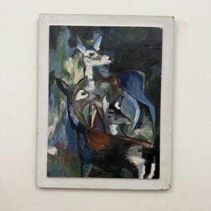 May include: An oil painting on a rectangular board featuring three deer in a forest setting. The artwork uses visible brushstrokes in shades of dark blue, black, brown, white, and green to depict the animals against a dark, moody background.