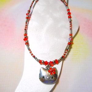 May include: Red and silver beaded anklet with a Hello Kitty charm. The charm has red rhinestones on the bow.