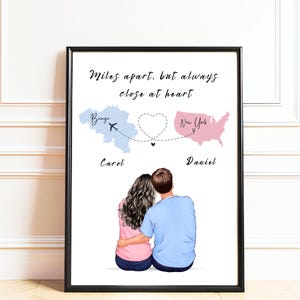 Puede incluir: Una lámina enmarcada con el texto Miles apart, but always close at heart. Muestra un mapa azul claro de Bélgica y un mapa rosa de EE. UU. conectados por una línea de puntos en forma de corazón, con dos personas sentadas juntas.