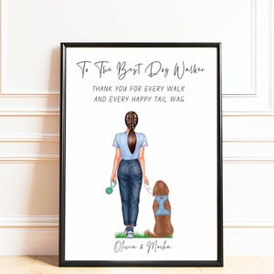 Peut inclure: Une impression encadrée illustrant une personne avec une queue-de-cheval tressée, portant un t-shirt bleu clair et un jean bleu, promenant un chien marron avec un harnais bleu. Le texte indique : To The Best Dog Walker, THANK YOU FOR EVERY WALK AND EVERY HAPPY TAIL WAG. Olivia & Mocha.