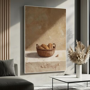 May include: A framed painting depicts a still life with a woven basket filled with loaves of bread. The painting has a neutral color palette with warm tones. A single bread roll sits outside the basket.