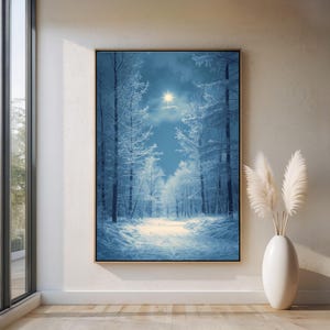 May include: A framed winter landscape painting. The artwork depicts a snow-covered forest with tall, bare trees and a path leading towards a bright light in the sky. The color palette is primarily cool tones of blue and white.