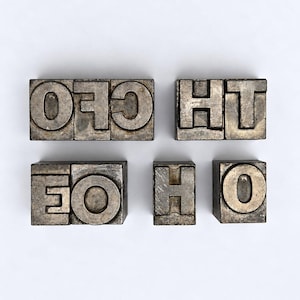 May include: A collection of seven rectangular metal letterpress blocks arranged in two rows. The top row features the letters O, F, C, T, and H. The bottom row displays the letters E, O, H, and O. Each block has a metallic, weathered finish.