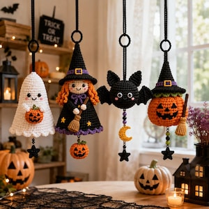 Puede incluir: Cuatro adornos de ganchillo colgantes que incluyen un fantasma blanco con una calabaza, una bruja de pelo naranja, un murciélago negro con una luna creciente amarilla y una calabaza de Halloween con sombrero de bruja, unidos por cordones negros.