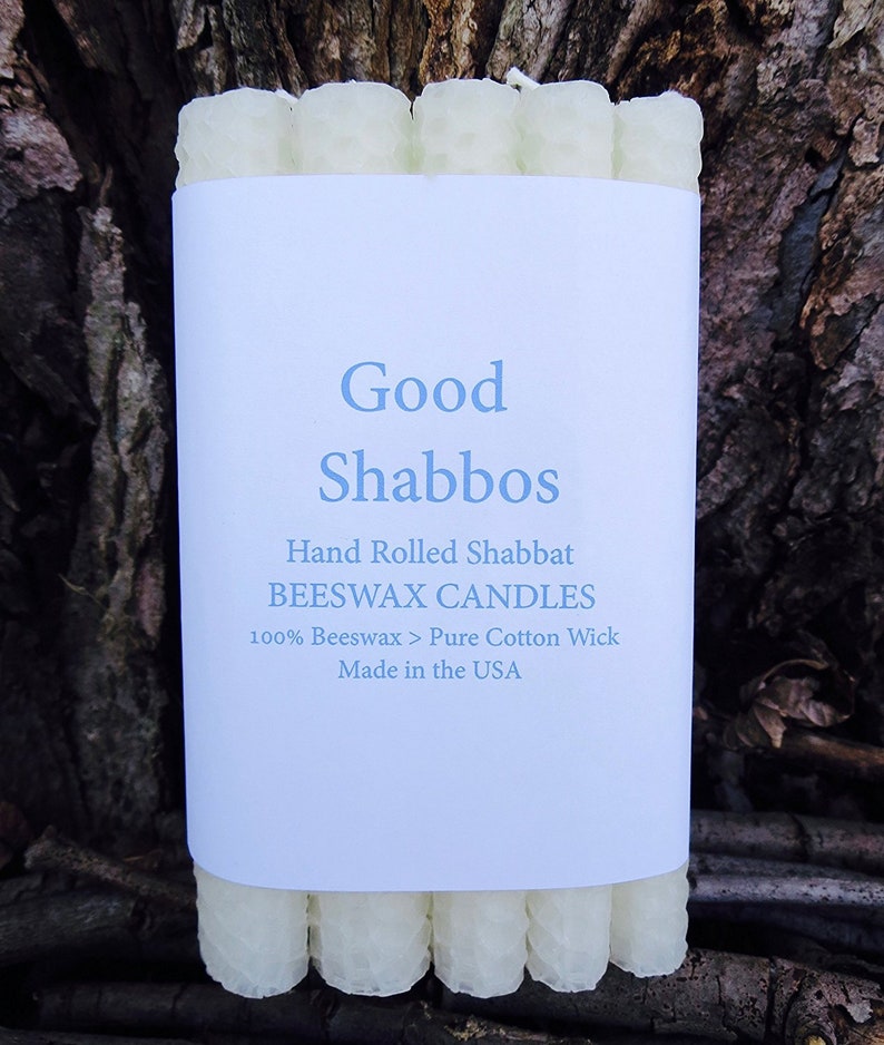 May include: A package of white beeswax candles with a label that reads "Good Shabbos", "Hand Rolled Shabbat Beeswax Candles", "100% Beeswax > Pure Cotton Wick", and "Made in the USA".