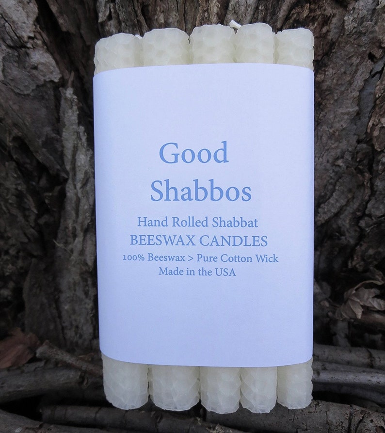 May include: A package of white beeswax candles with a label that reads "Good Shabbos", "Hand Rolled Shabbat Beeswax Candles", "100% Beeswax > Pure Cotton Wick", and "Made in the USA".