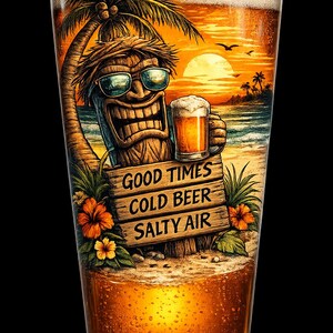 May include: A clear glass filled with golden beer featuring a graphic of a tiki figure wearing sunglasses, holding a smaller beer, and standing on a beach with a palm tree. A wooden sign reads GOOD TIMES COLD BEER SALTY AIR.
