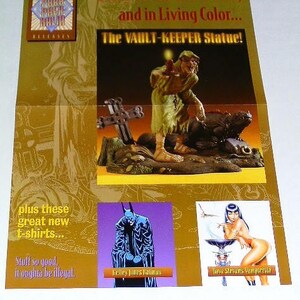 May include: A promotional card for a comic book series featuring a statue of a green, skeletal figure with a long beard and a lizard. The card also features images of a Batman character and a Vampirella character. The text on the card reads "Back from the Dead, and in Living Color... The Vault-Keeper Statue!"