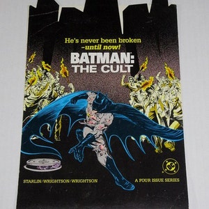 May include: A comic book cover featuring Batman in a dark blue suit with a cape, running towards the viewer. The cover is black with a dark grey background and features the text "Batman: The Cult" in white and yellow. The text "He's never been broken - until now!" is also featured in white and yellow. The cover also features the text "A Four Issue Series" in white.