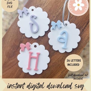 Può includere: Tre etichette bianche smerlate con lettere pastello e fiocchi decorativi. Le lettere sono S, A e H. Le etichette sono etichettate "DIGITAL SVG FILE" e "26 LETTERS INCLUDED". È presente anche il testo "instant digital download svg".
