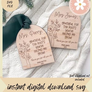 May include: Two wooden plaques with arched tops, engraved with floral designs and the words "Mrs. Perry" and "Mrs. Jones." The plaques read "Grateful for the roots you've helped me grow!" and "thank you for all you do!" with names and the year 2025.
