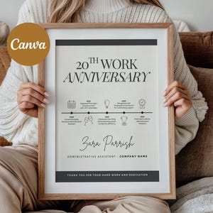 May include: A framed 20th Work Anniversary print. The print features a timeline with milestones, the name "Zara Parrish", and the title "Administrative Assistant". The design is in black and white with a wooden frame.
