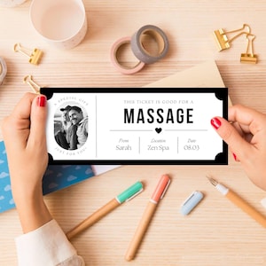 May include: A black and white massage gift certificate held by a person. The certificate reads "This ticket is good for a massage" and includes a photo, the giver's name, location, and date. Pens and stationery are in the background.