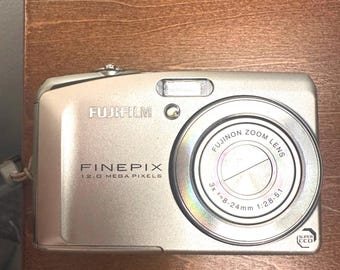 Cámara digital Fujifilm FinePix F50fd plateada de 12 MP. Batería, estuche, tarjeta SD de 2 GB, cables y cargador de pared incluidos.