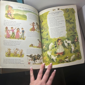 May include: Open book with colorful illustrations and text. The left page features a poem titled "Over the Hills and Far Away" with illustrations of children and animals. The right page has a poem titled "The Little Shepherdess to Her Lambs".