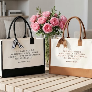 Tote bag design featuring a humorous quote reading the bag holds absolutely nothing urgent overwhelming or stressful displayed in bold uppercase lettering with a clean and centered layout; includes a small retired life phrase underneath for added personality; designed with a minimal modern style that highlights the text clearly; ideal for retirement gifts, everyday use, or carrying essentials with a lighthearted and relaxed vibe