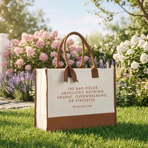 Tote bag design featuring a humorous quote reading the bag holds absolutely nothing urgent overwhelming or stressful displayed in bold uppercase lettering with a clean and centered layout; includes a small retired life phrase underneath for added personality; designed with a minimal modern style that highlights the text clearly; ideal for retirement gifts, everyday use, or carrying essentials with a lighthearted and relaxed vibe