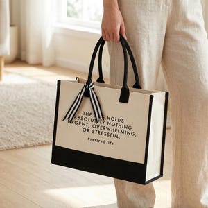 Tote bag design featuring a humorous quote reading the bag holds absolutely nothing urgent overwhelming or stressful displayed in bold uppercase lettering with a clean and centered layout; includes a small retired life phrase underneath for added personality; designed with a minimal modern style that highlights the text clearly; ideal for retirement gifts, everyday use, or carrying essentials with a lighthearted and relaxed vibe