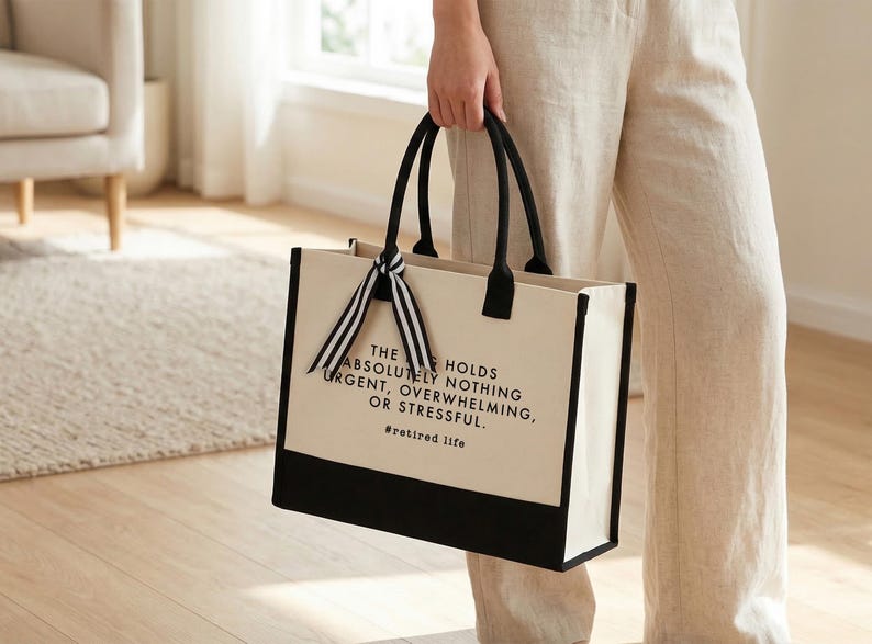 Tote bag design featuring a humorous quote reading the bag holds absolutely nothing urgent overwhelming or stressful displayed in bold uppercase lettering with a clean and centered layout; includes a small retired life phrase underneath for added personality; designed with a minimal modern style that highlights the text clearly; ideal for retirement gifts, everyday use, or carrying essentials with a lighthearted and relaxed vibe