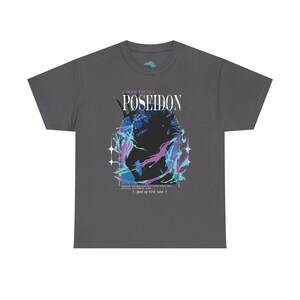 May include: Dark gray t-shirt featuring the word "POSEIDON" above a graphic of a figure with blue and purple accents. The text "GOD OF THE SEA" is above the word "POSEIDON". Additional text is below the graphic.