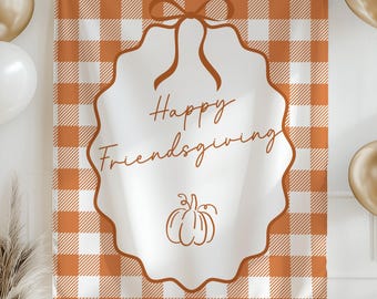 May include: A fall-themed banner with a white and orange gingham pattern. The banner features the words "Happy Friendsgiving" in elegant script, along with a pumpkin illustration. Gold and white balloons and decorative elements complete the festive scene.